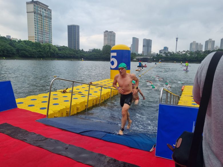 이날 오전 7시 8분께 참가자들이 석촌호수를 한 바퀴 수영한 뒤 두 번째 바퀴를 돌기 위해 올라오고 있다.