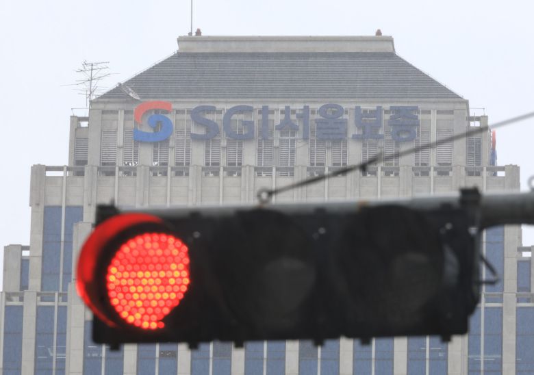 SGI서울보증 전산 시스템이 랜섬웨어 공격으로 마비된 14일, 건물 위에 설치된 빨간 신호등이 정지된 금융 업무 상황을 상징하고 있다.