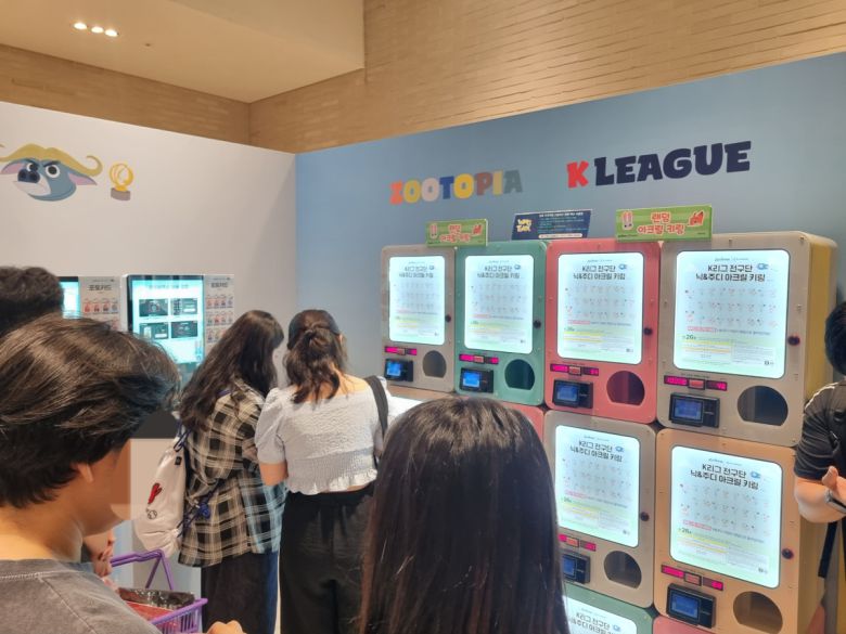 25일 'K리그-주토피아' 팝업스토어에서 방문객들이 매장 내 캡슐토이 키오스크를 통해 구단별 랜덤 디자인의 닉&주디 아크릴 키링을 뽑고 있다.