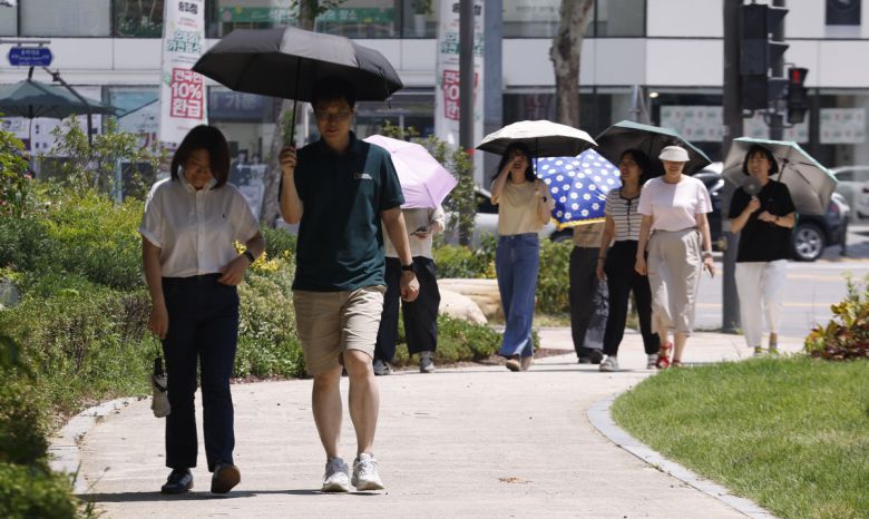 서울 낮 최고기온이 37도를 기록하는 등 전국 대부분 지역에 폭염이 기승을 부린 지난달 29일 서울 송파구 석촌호수 인근에서 양산을 쓴 시민들이 더위를 피해 발걸음을 옮기고 있다. 조현호 기자 hyunho@