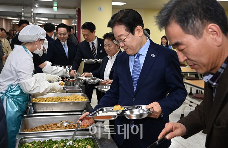 2024년 11월 27일 당시 이재명 더불어민주당 대표가 서울 성동구 금호고에서 열린 고교 무상교육을 위한 현장 간담회를 마치고 식생활 교육실에서 배식을 받고 있다.
