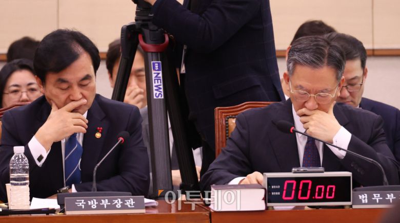 정성호(오른쪽) 법무부 장관과 안규백 국방부 장관이 7일 서울 여의도 국회에서 열린 법제사법위원회 전체회의에서 얼굴을 만지고 있다. 고이란 기자 photoeran@