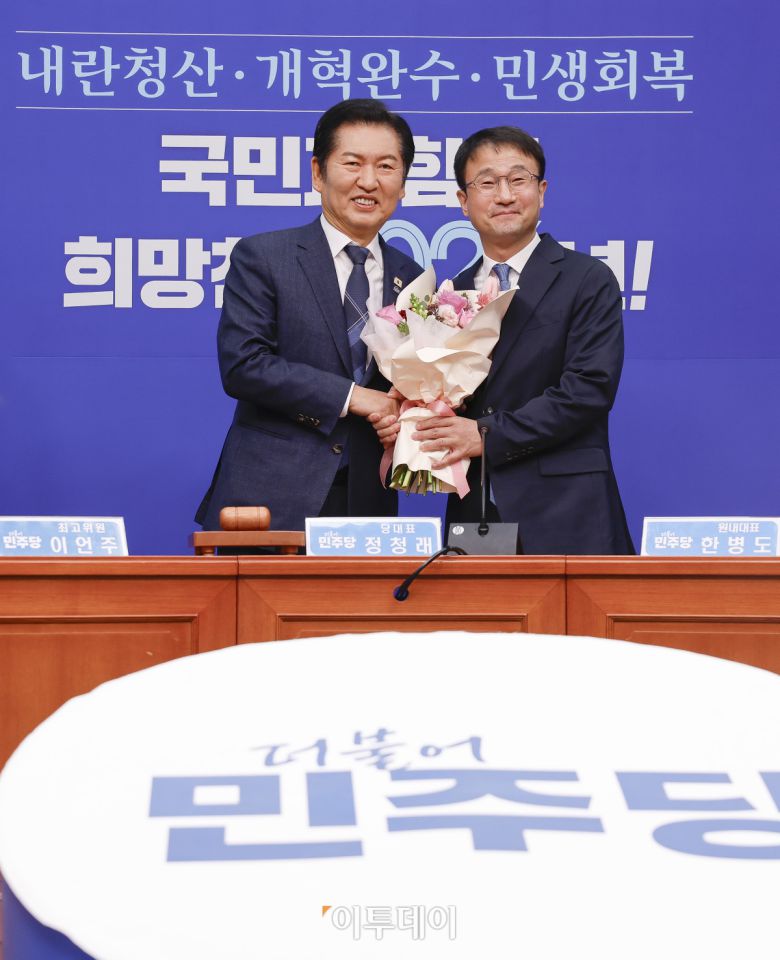 더불어민주당 한병도(오른쪽) 신임 원내대표가 12일 서울 여의도 국회에서 열린 더불어민주당 최고위원회의에서 정청래 대표에게 꽃다발을 전달받은 후 기념촬영을 하고 있다. 조현호 기자 hyunho@