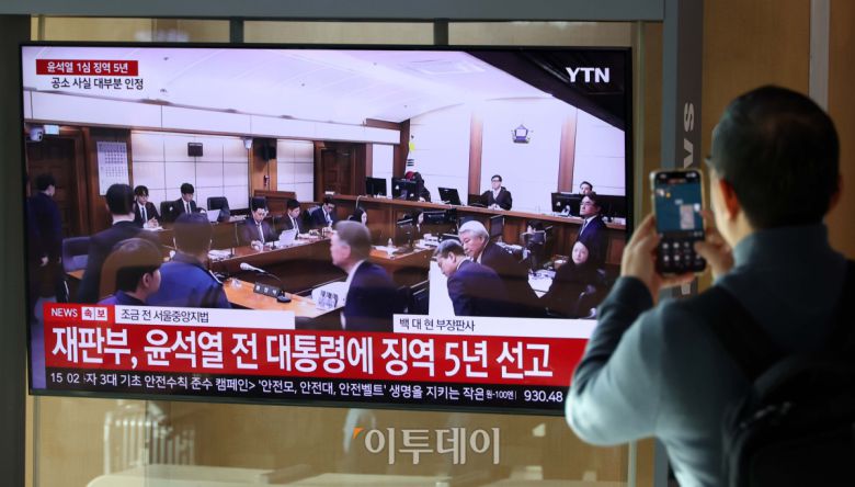 16일 서울역 대합실에서 시민들이 고위공직자범죄수사처(공수처)의 체포영장 집행 방해 등 혐의로 재판에 넘겨진 윤석열 전 대통령의 1심 선고 공판 생중계를 지켜보고 있다. 법원은 윤 전 대통령에게 징역 5년을 선고했다. 이번 선고는 내란 관련 사건 재판 중 처음으로 나오는 판결이다. 고이란 기자 photoeran@