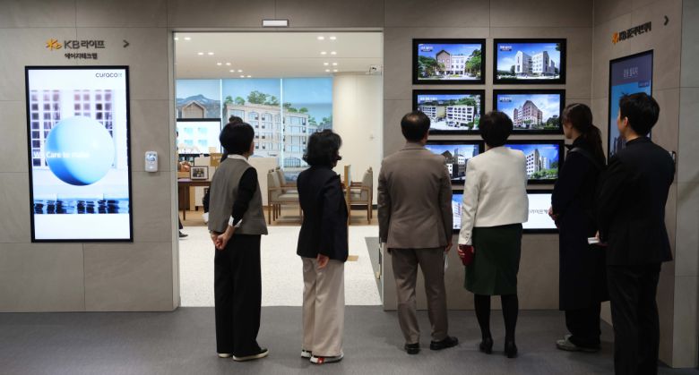 20일 서울 강남구 KB라이프타워에서 열린 KB금융그룹 ‘KB골든라이프 플래그십 센터’ 개소식에서 참석자들이 시니어를 위한 최신 기술 체험·연구 공간인 ‘에이지테크랩(Age Tech Lab)’을 둘러보고 있다. ‘KB골든라이프 플래그십 센터’는 보험·요양·은행 서비스를 결합한 보험-은행 복합점포로 고객의 생애 주기 전반을 아우르는 그룹 통합 시니어 서비스를 제공한다. 신태현 기자 holjjak@
