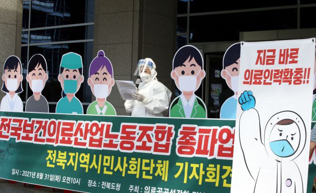 ▲보건의료 노동자들이 공공의료 확충을 요구하며 9월 2일 총파업을 예고한 가운데, 전북 시민단체들은 31일 전북도청 앞에서 파업을 지지하는 기자회견을 하고 있다. 단체는 전주시가 사회적 거리두기 4단계를 적용 중인 만큼 얼굴 모양이 그려진 판넬을 기자회견장에 세웠다. ⓒ연합뉴스