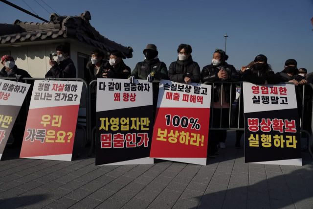 ▲22일 서울 종로구 광화문 시민열린마당에서 방역패스 철회 등을 요구하는 자영업자들의 집회가 열렸다. 경찰은 미리 펜스를 설치해 집회 기준인 299인의 행사장 입장을 허용했다. 이에 따라 많은 자영업자들은 펜스 바깥에서 행사에 참여했다. ⓒ프레시안(최용락)