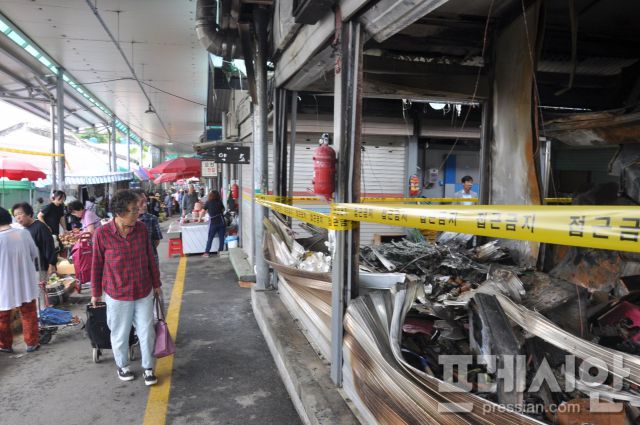 ▲ 21일 광주 광산구 비아5일시장 손님들이 불에 탄 점포를 지켜보고 있다. ⓒ프레시안(임채민)