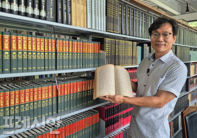 ▲심상무 고북역사책박물관 대표가 가장 소중하게 아끼는 중국고중세사를 들어보이고 있다. 이 책은 전남대학교 인문대학 사학과에서 만든 것으로 처음부터 끝까지 자필본으로 돼 있다 ⓒ프레시안(김규철)