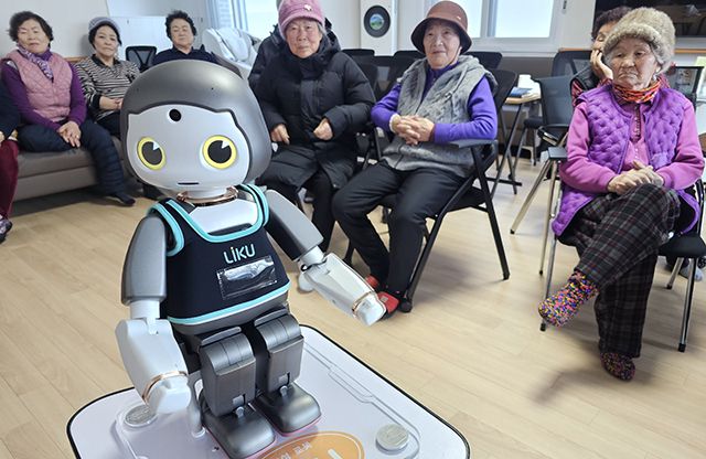 ▲지난 10일 태백시 화전1경로당에서 AI돌봄 로봇이 오늘의 날씨를 전하며 인사하자 어르신들이 신기한듯 바라보고 있다. ⓒ프레시안