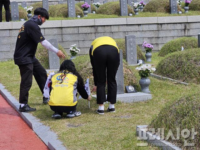 ▲13일 한국도로공사서비스 광주전남권역본부 직원들이 묘역마다 태극기를 꽂는 자원봉사에 참여했다.2025.05.13ⓒ프레시안(김보현)
