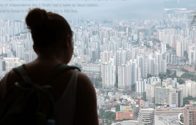 ▲지난 14일 서울 남산 N서울타워에서 한 외국인 관광객이 서울 시내 아파트단지 전경을 살펴보고 있다. ⓒ연합뉴스