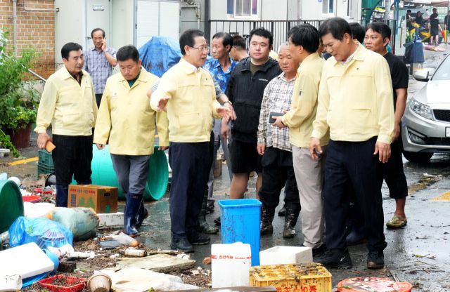 ▲4일 오전 극한호우가 쏟아진 함평군 천지전통시장에서 김영록 전남도지사가 피해 현황을 청취하고 신속한 복구 대책을 당부하고 있다.2025.08.04ⓒ전남도 제공