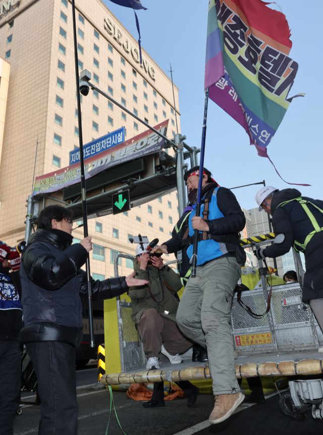 ▲세종호텔 앞 도로에 있는 10ｍ 높이 구조물에 올라 복직을 요구하며 336일째 농성을 벌였던 서비스연맹 관광레저산업노조 세종호텔지부 고진수 지부장이 14일 서울 중구 세종호텔 앞 구조물에서 내려오고 있다. ⓒ연합뉴스