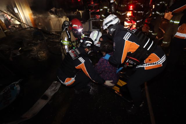 ▲22일 오전 5시 14분께 경북 포항시 남구 구룡포읍 구룡포 전통시장에서 발생한 화재 현장에서 소방대원들이 거동이 불편한 70대 여성을 구조하고 있다.ⓒ포항남부소방서 제공