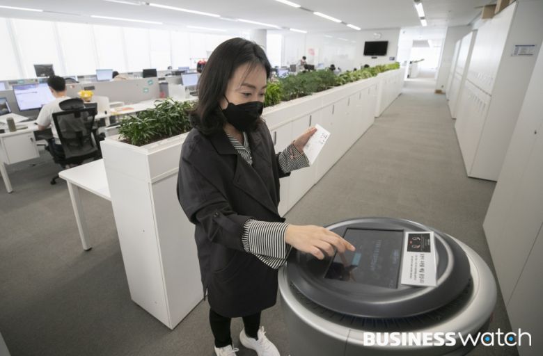 자율주행 우편배달로봇이 사무실로 도착하자 수신인이 우편물을 수령하고 있다. /사진=이명근 기자 qwe123@