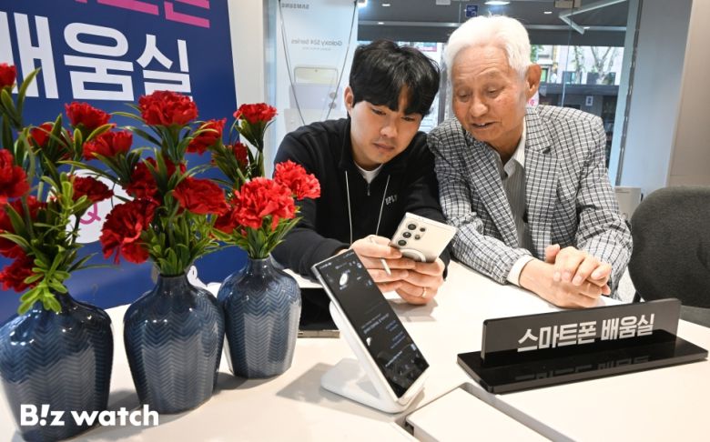 7일 오전 서울 종로구 LG유플러스 종로5가역점에 마련된 우리동네 스마트폰 배움실에서 시니어 모델들이 관계자에게 AI번역기능을 배우고 있다./사진=이명근 기자 qwe123@