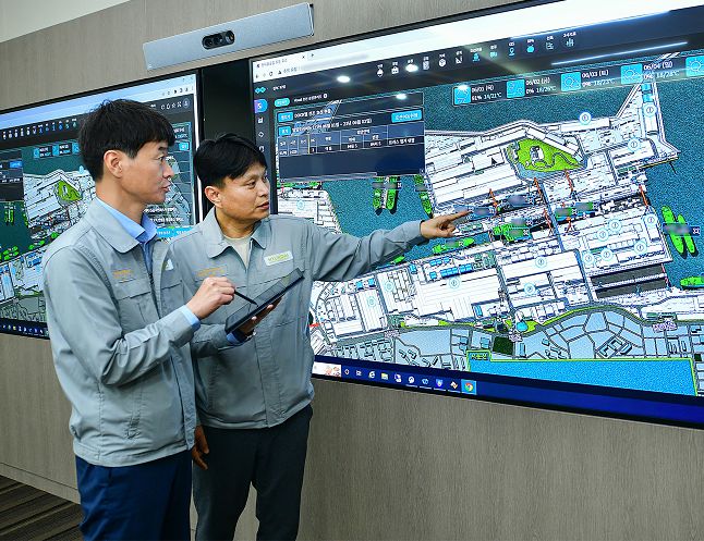 HD현대중공업 직원들이 디지털 트윈을 활용한 가상 조선소 '트윈포스(TWIN FOS)'를 통해 조선소 공정 상황을 실시간으로 살펴보고 있다./사진=HD현대 제공