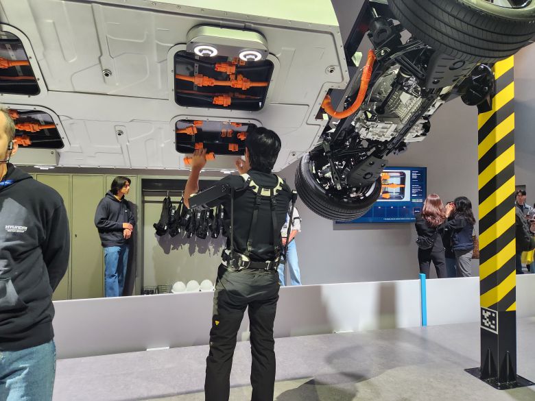 시연자가 산업용 착용로봇 '엑스블 숄더(X-ble Shoulder)'를 착용하고 현대차그룹의 전동화 전용 플랫폼인 E-GMP 윗보기 작업을 하고 있다./사진=도다솔 기자