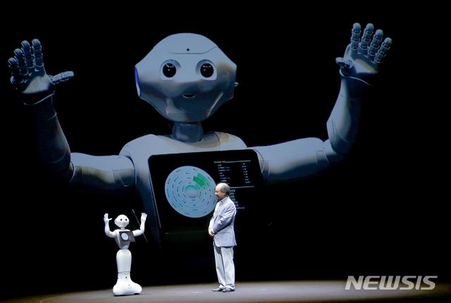 [도쿄=AP/뉴시스]지난 2015년 6월 18일 소프트뱅크그룹 회장 손정의(일본명 손 마사요시)가 기자 간담회에서 로봇 페퍼를 선보이고 있다. 2021.06.29.