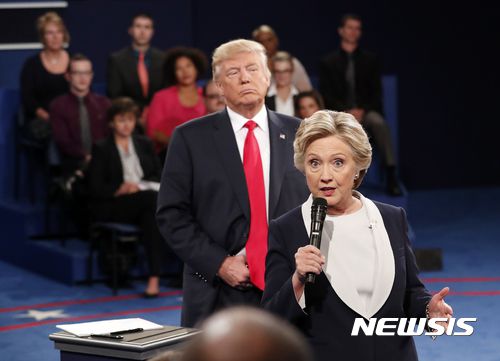 [세인트루이스=AP/뉴시스] 힐러리 클린턴 전 국무장관이 지난 2016년 10월9일 세인트루이스 워싱턴대학에서 열린 미 대선 2차 TV토론회에서 연설하고 있고 공화당 도널드 트럼프 후보가 뒤에서 듣고 있다. 2017.08.24