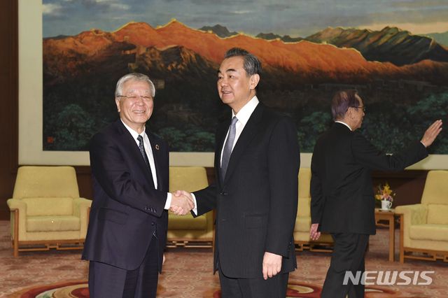 [도쿄=AP/뉴시스]지난 2018년 10월 10일 중국 베이징 인민대회당을 방문한 나카니시 히로아키 일본 게이단렌 회장(왼쪽)이 왕이 중국 외교 담당 국무위원 겸 외교부장(오른쪽)과 악수하고 있다. 2021.05.10.