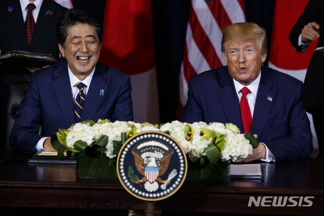 【뉴욕=AP/뉴시스】도널드 트럼프(오른쪽) 미국 대통령과 아베 신조 당시 일본 총리가 지난해 9월 25일(현지시간) 유엔총회가 열리고 있는 뉴욕의 인터콘티넨탈 호텔에서 미·일 무역협정서에 서명하기 전 웃으며 얘기하고 있다. 2019.09.26.