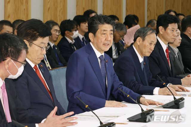 [도쿄=AP/뉴시스]아베 신조 일본 총리(가운데)가 지난 26일 총리 관저에서 특별조치법에 근거한 코로나19 관련 대책 본부를 설치한 후 첫 회의를 가지고 있다. 회의에는 가토 가쓰노부 후생노동상, 니시무라 야스토시(西村康稔) 경제재정·재생상, 스가 요시히데 관방장관 등이 참석했다. 대책 본부 설치로 아베 총리는 긴급 사태 선언이 가능해졌다. 2020.03.27