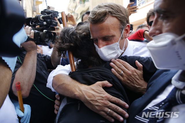 [베이루트=AP/뉴시스]에마뉘엘 마크롱 프랑스 대통령이 6일(현지시간) 레바논 베이루트 항구 폭발 참사 현장을 방문해 한 주민을 안아주며 위로하고 있다. 마크롱 대통령은 레바논과 수도 베이루트의 재건을 위해 국제 지원 조직에 앞장설 것을 약속하면서 "개혁이 이뤄지지 않으면 레바논은 계속 가라앉을 것"이라고 경고했다. 2020.08.06.