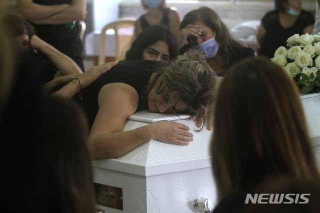 [베이루트=AP/뉴시스]6일(현지시간) 레바논 남부 사르바 마을에서 베이루트 항구 폭발 참사로 숨진 딸의 장례식에 참석한 어머니(가운데)와 딸의 관을 붙잡고 오열하고 있다. 에마뉘엘 마크롱 프랑스 대통령은 베이루트에서 발생한 대규모 폭발 사건에 대한 독립적이고 투명한 조사가 필요하다고 주장했다. 마크롱 대통령이 시내를 방문하는 동안 분노한 레바논 사람 수백 명이 반정부 시위를 벌였다. 2020.08.07.