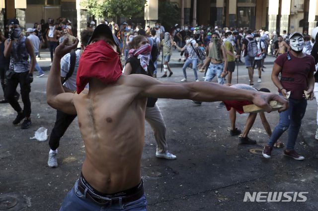 [베이루트=AP/뉴시스]10일(현지시간) 레바논 베이루트에서 베이루트 폭발 참사에 분노한 시위대가  반정부 시위를 벌이며 시위 진압 경찰을 향해 돌을 던지고 있다. 레바논 내각이 베이루트 폭발 참사의 책임을 지고 총사퇴했다. 하산 디아브 레바논 총리는 이날 대국민 연설을 통해 "내각 사퇴를 선언한다"라며 국민과 함께 변화를 위해 싸우겠다고 밝혔다. 2020.08.11.