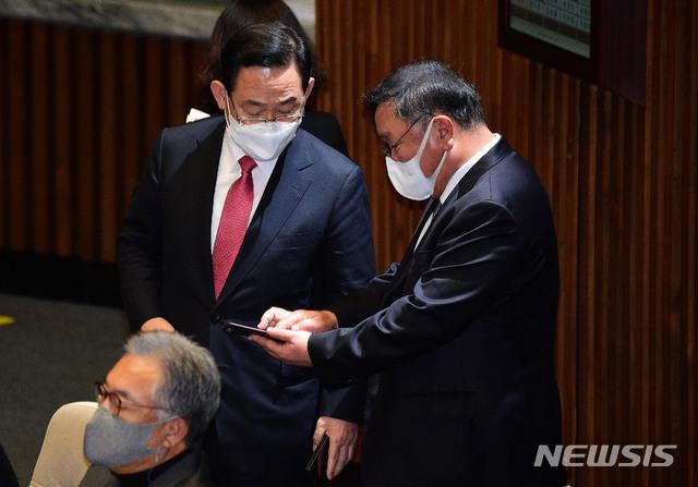 [서울=뉴시스] 김진아 기자 = 김태년 더불어민주당 원내대표와 주호영 국민의힘 원내대표가 19일 서울 여의도 국회에서 열린 본회의에 휴대전화를 보며 대화를 니누고 있다. (공동취재사진)  2020.11.19 photo@newsis.com