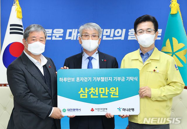 [대전=뉴시스]조명휘 기자 = 하나은행충청영업그룹이 27일 오전 대전시청 응접실에서 '하루만보 혼자걷기 기부 챌린지'를 통해 마련한 성금 3000만원을 대전사회복지공동모금회에 기탁하고 있다.왼쪽부터 정태희 대전사회복지공동모금회 회장, 윤순기 하나은행 충청영업그룹 총괄대표, 허태정 대전시장. (사진= 대전시 제공). 2020.11.27.  photo@newsis.com