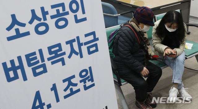 [서울=뉴시스]조수정 기자 = 소상공인 버팀목자금(3차 재난지원금) 신청 첫날인 11일 오전 서울 종로구 소상공인시장진흥공단 서울중부센터에서 직원들이 온라인 접수가 어려운 시민들의 신청을 돕고 있다.  2021.01.11. chocrystal@newsis.com