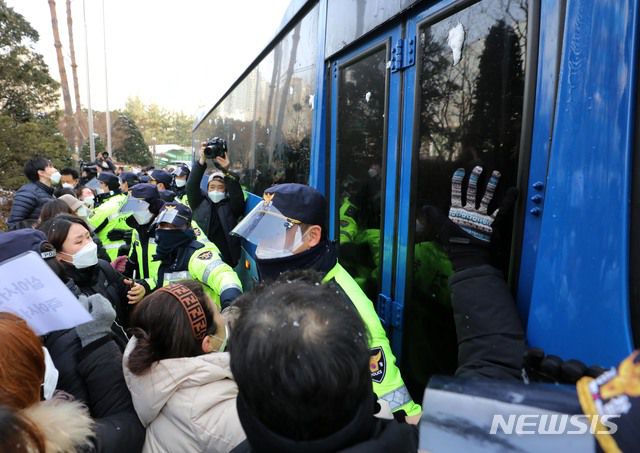 [서울=뉴시스]배훈식 기자 = 학대 받아 숨진 것으로 조사된 정인이의 입양부모에 대한 첫 재판이 열린 지난달 13일 오전 서울 양천구 서울남부지법에서 시민들이 입양모가 탄 호송차량을 막아서며 항의하고 있다.(공동취재사진) 2021.01.13. photo@newsis.com