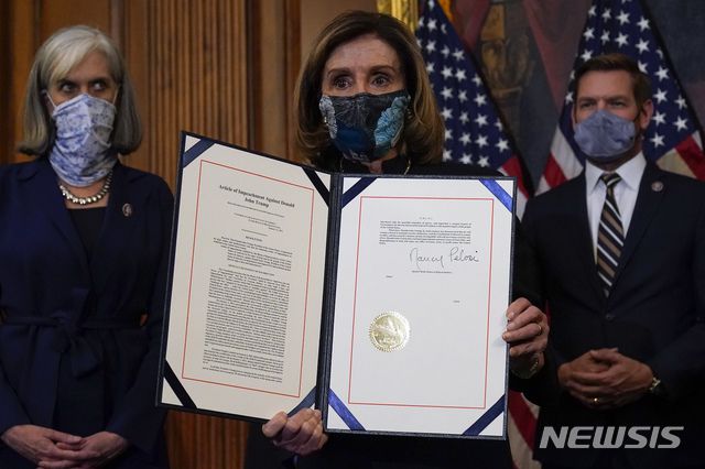 [워싱턴=AP/뉴시스]낸시 펠로시 미 하원의장이 지난달 13일(현지시간) 의회에서 도널드 트럼프 대통령의  탄핵소추안에 서명 후 이를 들어 보이고 있다. 2021.2.9.