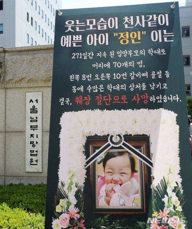 [서울=뉴시스]박주성 기자 = 양모의 학대 끝에 숨진 16개월 된 입양 딸 '정인이'의 양부모의 1심 결심공판이 열린 지난 4월14일 오후 서울 양천구 서울남부지법 입구에 정인이의 사진이 있는 플래카드가 놓여 있다. 2021.04.14. park7691@newsis.com