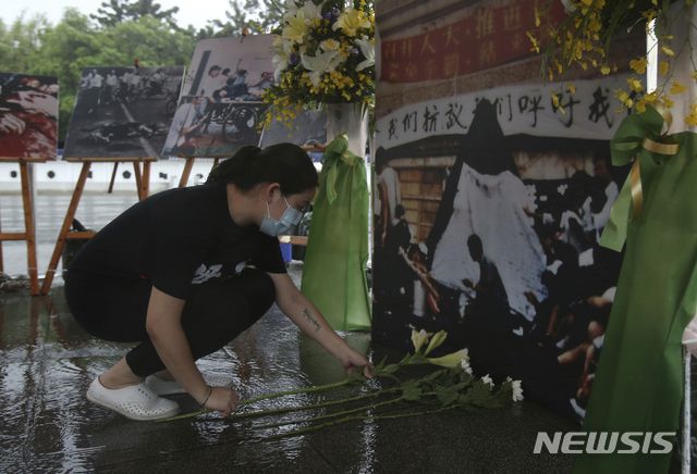 [타이베이=AP/뉴시스] 대만 수도 타이베이 민주광장에서 2021년 6월 4일 코로나19 예방을 위해 마스크를 착용한 여성이 중국군이 민주화 시위대를 유혈진압한 톈안먼 사태 32주년을 맞아 희생자를 추모하는 제단에 헌화하고 있다. 2024.08.22.