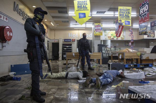 [요하네스버그=AP/뉴시스] 12일(현지시간) 남아프리카공화국 요하네스버그의 한 상점에서 경찰이 약탈범들을 체포하고 있다. 경찰은 제이콥 주마 전 대통령의 수감 이후 폭동과 약탈이 고조되면서 6명이 숨지고 200명 이상이 체포됐다고 밝혔다. 2021.07.13.