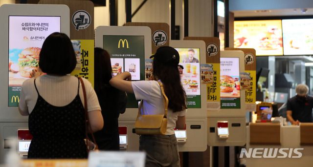 [서울=뉴시스] 서울 중구 도심의 한 패스트푸드점에서 고객들이 키오스크로 주문을 하고 있다. photo@newsis.com