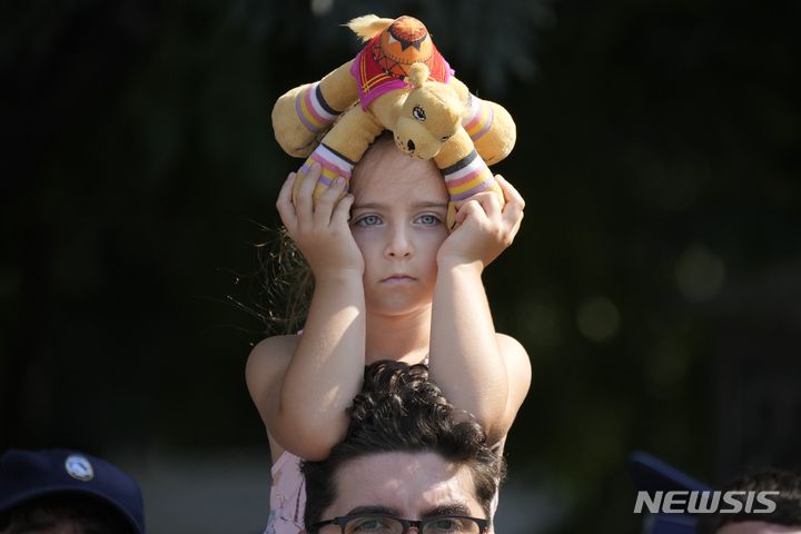 [부쿠레슈티(루마니아)=AP/뉴시스] 지난 7월 21일 루마니아 부쿠레슈티트 시내에서 열린 아프간주둔군 철수완료 기념식을 지켜보는 아이.