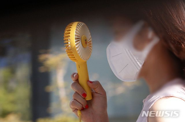 [서울=뉴시스] 홍효식 기자 = 연일 폭염이 이어지고 있는 28일 서울 중구 거리에서 한 시민이 손 선풍기를 들고 더위를 식히고 있다. 2021.07.28. yesphoto@newsis.com