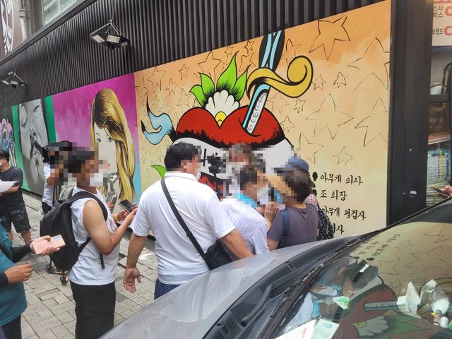 [서울=뉴시스] 정유선 기자=서울 종로구 한 중고서점의 '쥴리 벽화' 앞에서 시민들이 다툼을 벌이고 있다.  2021. 7. 29.  *재판매 및 DB 금지