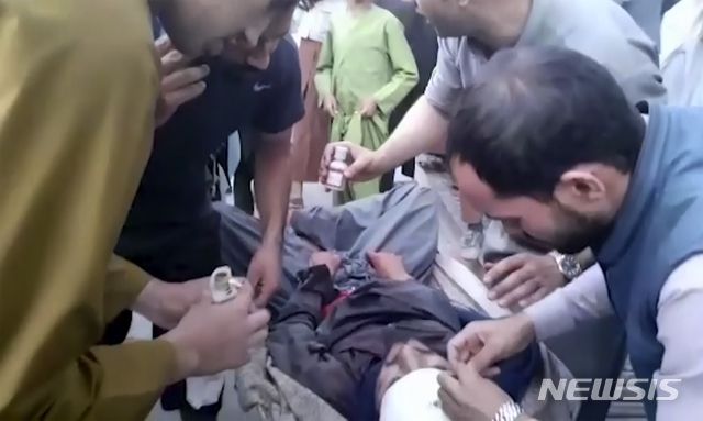 [카불=AP/뉴시스]지난 26일(현지시간) 아프가니스탄 카불 공항 외곽에서 발생한 IS-K의 자살폭탄 테러 부상자를 사람들이 돌보고 있다. 2021.08.27.