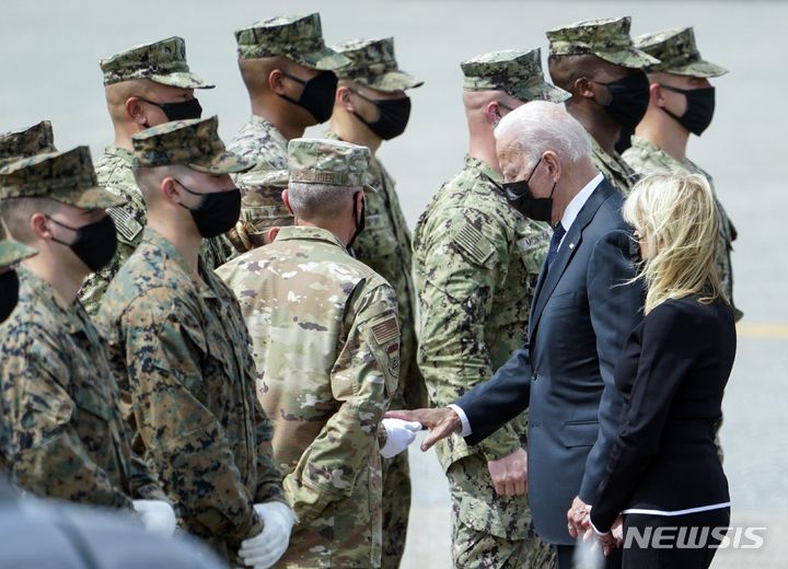 [도버 공군기지=AP/뉴시스]2021년 8월29일(현지시간) 미 델라웨어주 도버 공군기지에서 조 바이든 대통령과 영부인 질 바이든 여사가 아프가니스탄 카불 공항 자폭테러로 숨진 미군 장병에게 경의를 표하고 있다. 2024.08.27.