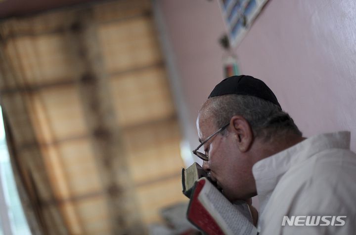 [카불( 아프가니스탄)=AP/뉴시스] 아프간 카불에 남아있던 유일한 유대교 장례사이자 랍비인 제불론 시멘토프가 8월 29일 카불의 성전에서 기도서에 입맞추고 있다. 그는 29명의 유대인 여성,어린이들과 함께 버스로 출국했다.