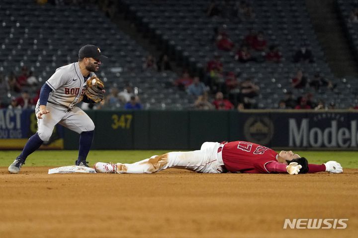 [애너하임=AP/뉴시스] 로스앤젤레스 에인절스의 지명타자 오타니 쇼헤이(오른쪽)가 22일(현지시간) 미 캘리포니아주 애너하임의 에인절 스타디움에서 열린 2021 메이저리그(MLB) 휴스턴 애스트로스와의 경기 4회 2루 도루에 실패한 후 운동장에 누워있다. 오타니는 45홈런으로 메이저리그 전체 홈런 3위를 달리고 있으며 공동 선두와는 1개 차이다. 2021.09.23.