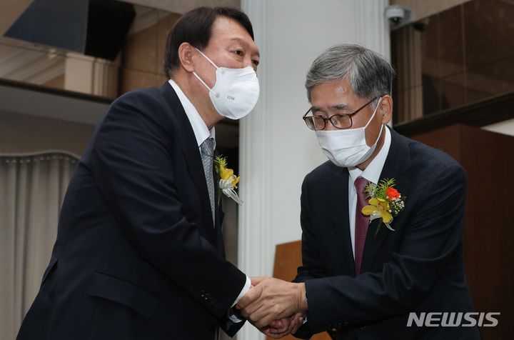 [서울=뉴시스] 국회사진기자단 = 윤석열 국민의힘 대선 후보가 9일 서울 중구 프레스센터에서 열린 신평 변호사 출판기념회에서 신 변호사와 악수하고 있다. 2021.11.09. photo@newsis.com