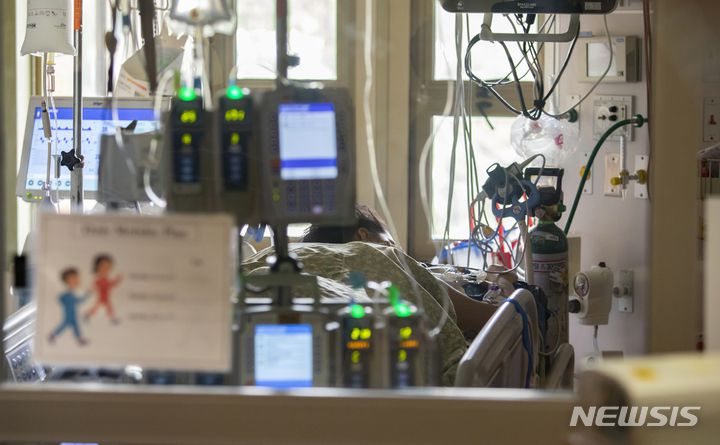 [보이시(미 아이다호주)=AP/뉴시스]지난 8월31일 미 아이다호주 보이시의 세인트 루크 보이시 병원에 한 임신한 코로나19 감염자가 호스를 낀 채 병상에 앉아 있다. 2021.12.29.