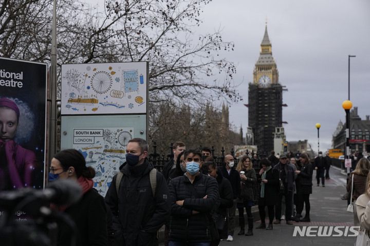 [런던(영국)=AP/뉴시스] 지난 13일(현지시간) 영국 런던의 세인트 토마스 병원 앞에 코로나19 백신 부스터샷 접종 줄이 길게 늘어서 있다. 2021.12.15.